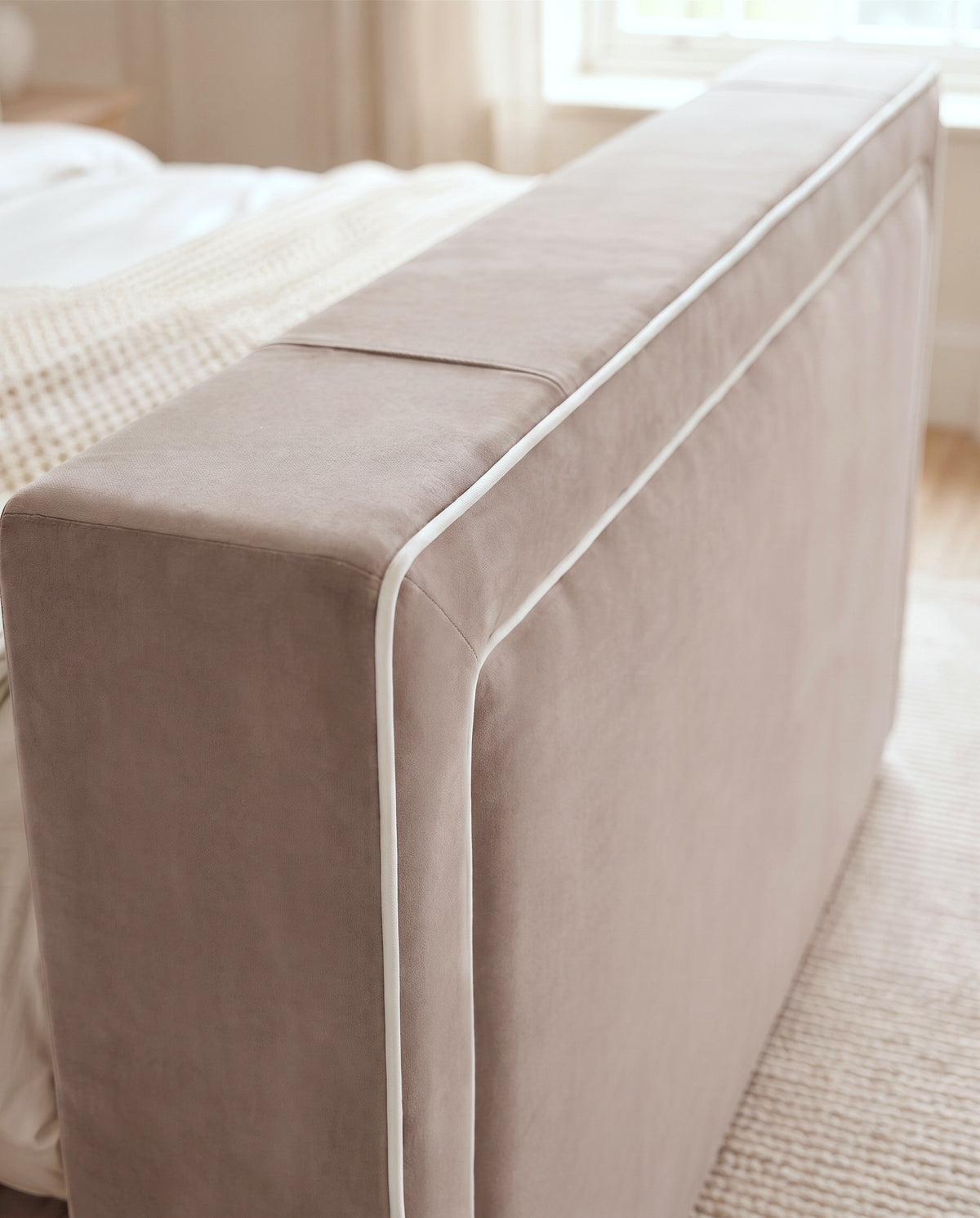 Hampton TV Bed footboard close-up in taupe plush velvet with two rows of white piping